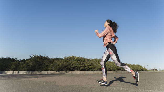 マラソンレース完走するために腰高のランニングフォームでトレーニングする女性